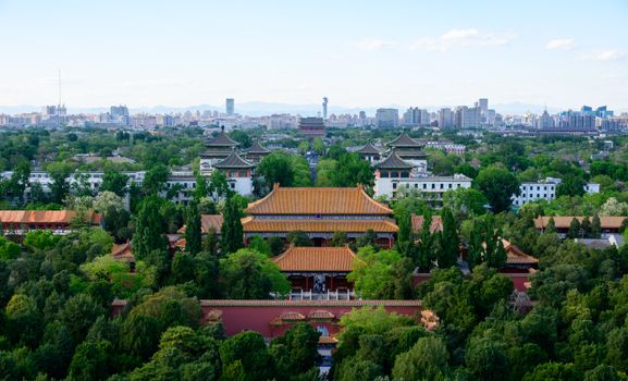 A stunning aerial view of ancient Chinese architecture with Beijing's city skyline in the background.